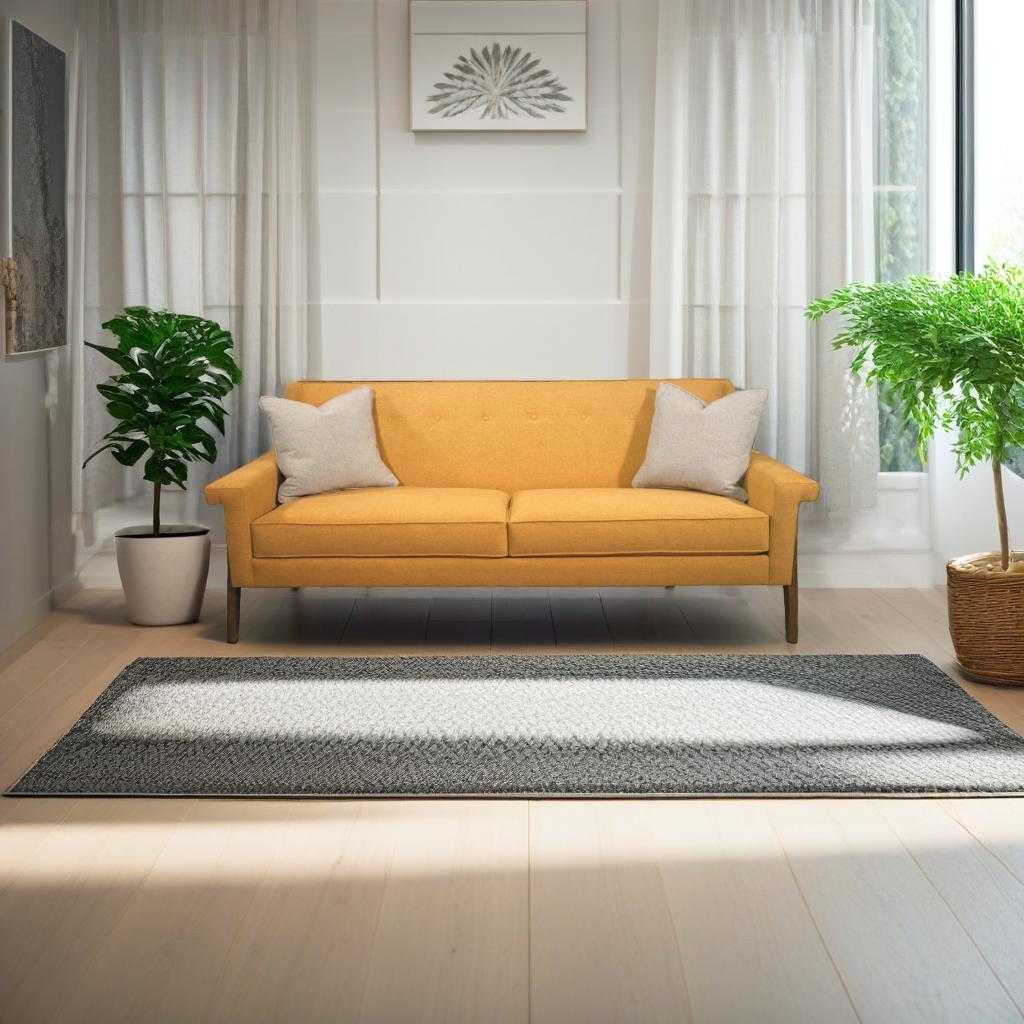 A mustard yellow mid-century modern sofa with button-tufted detailing on the backrest, paired with a light gray throw pillow.